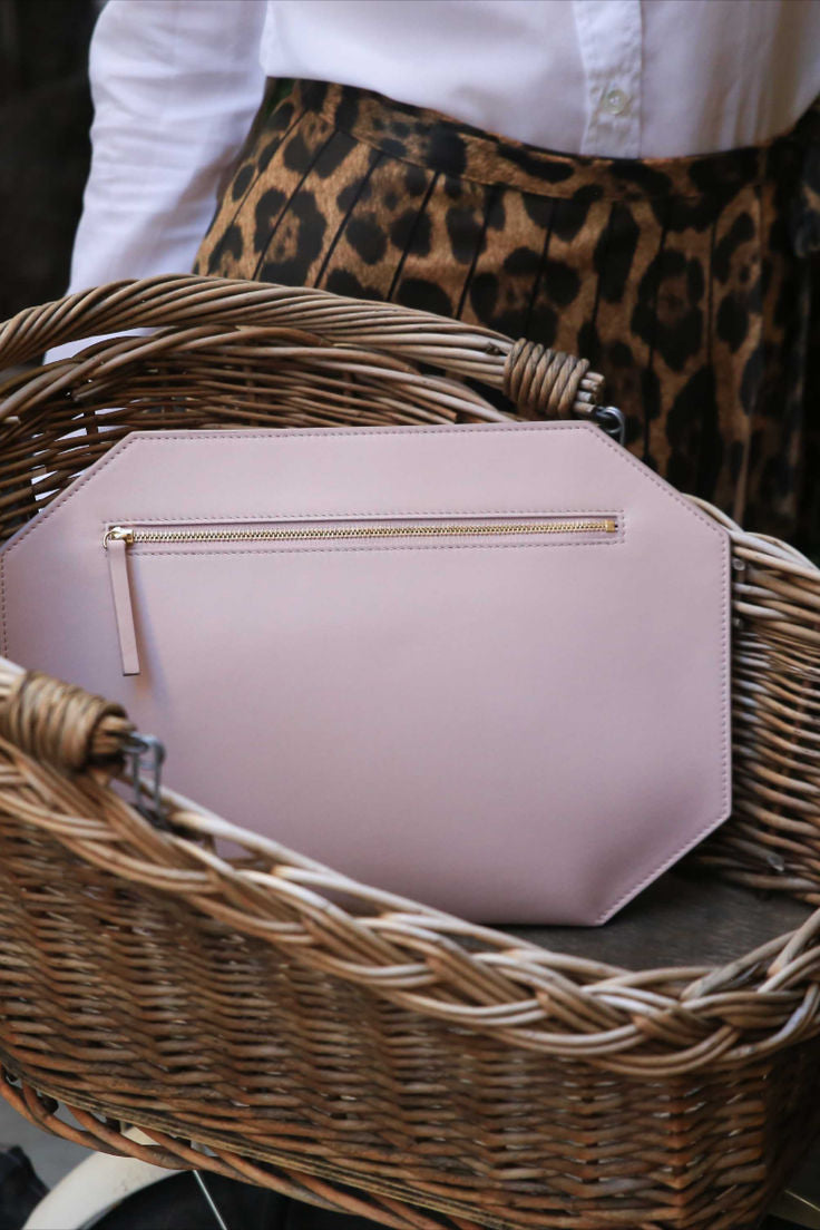 CHANDRA KEYSER Andiamo pink crossbody bag, evening clutch sitting on a wicker chair