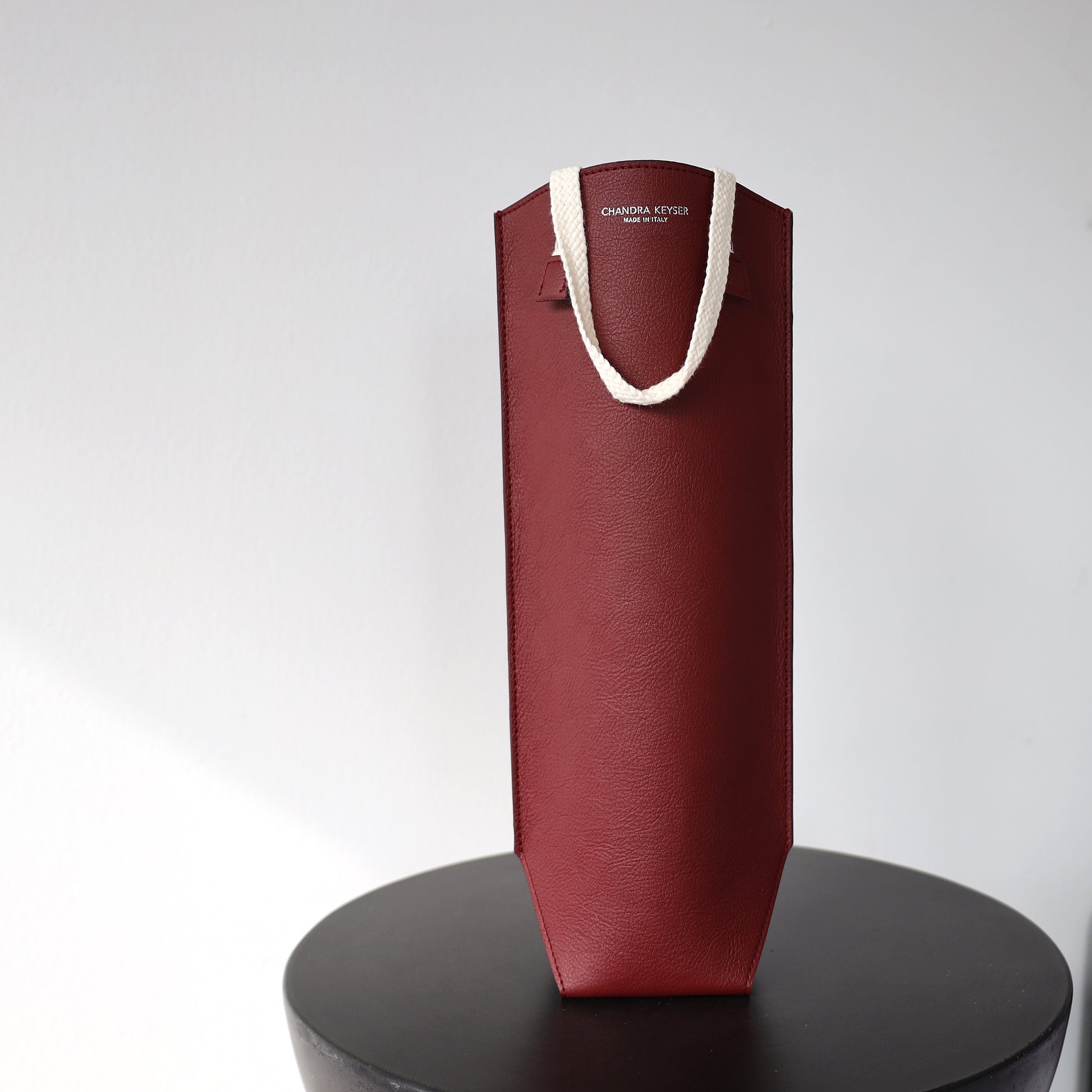 Bordeaux Bag Wine Carrier Sustainable Luxury Gift Circular Product Supports the Environment sitting on a round table with white wall in the background