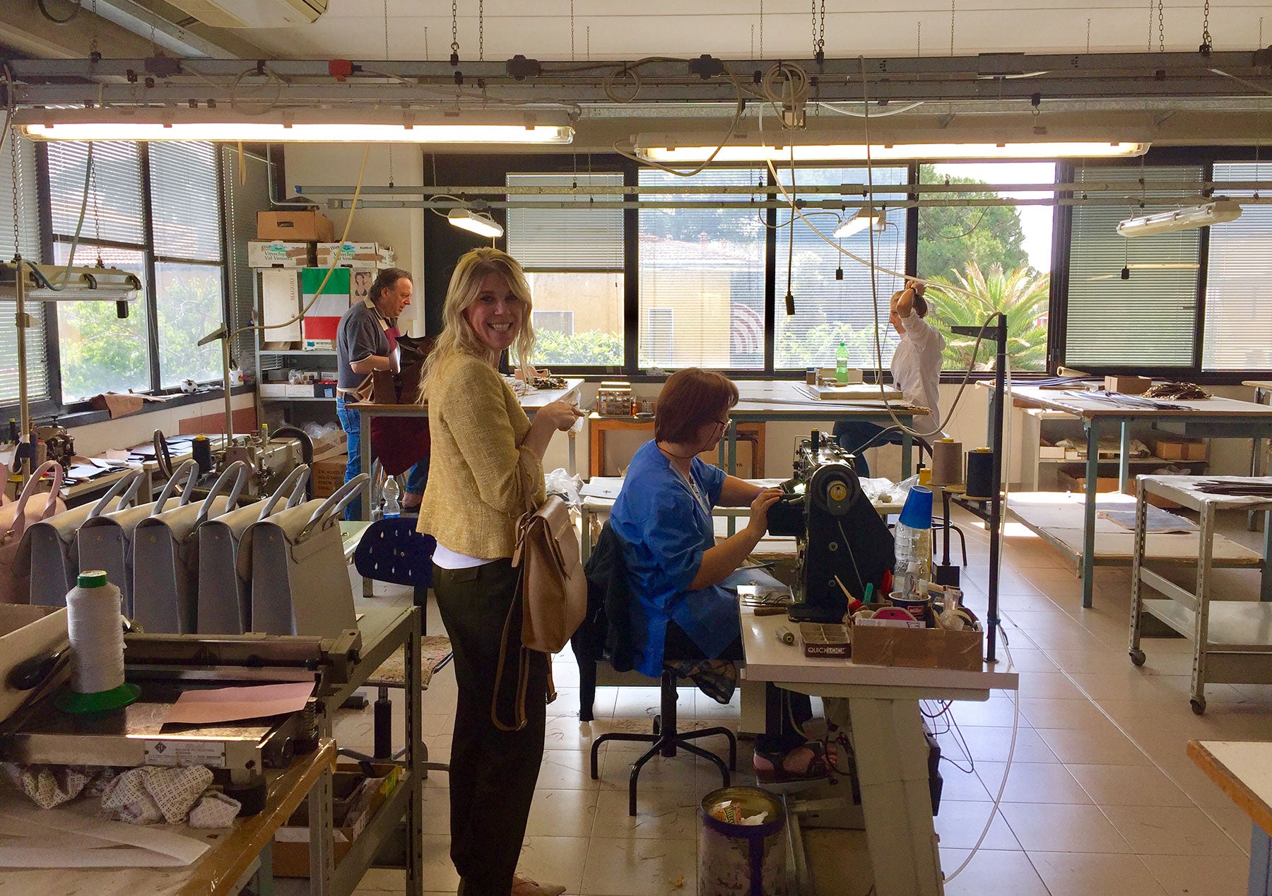 Chandra Keyser inside the family owned factory in Scandicci, Italy with an Italian craftswoman sewing Lo Zaino Leather Backpack 
