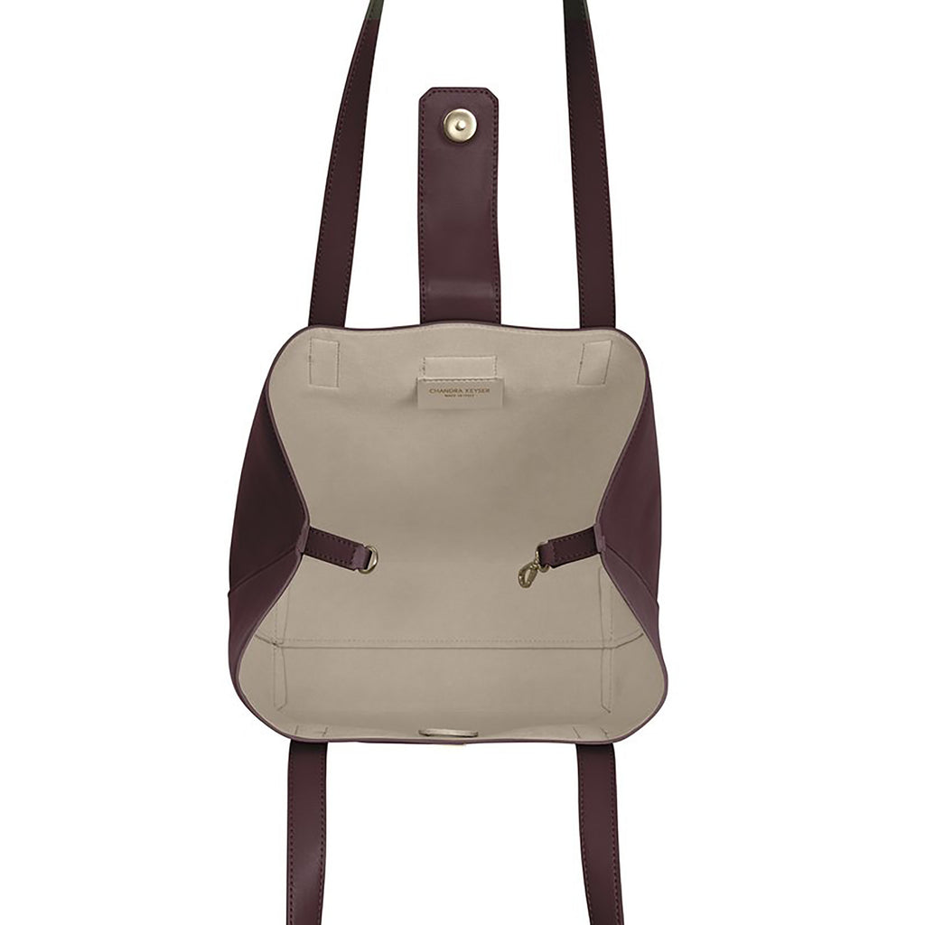 Lightweight bucket bag has two shoulder straps, snap closure, separate micro-suede zip pouch and inside clasp to contract and expand bag  100% leather, smooth matte texture Magnet snap closure Micro-suede lining Two shoulder straps, 10” drop Micro-suede zip pouch can easily be attached to inside of bag Tote measures: 12”h x 11”w x 4”d Pouch measures: 5”h x 8”w x .5”d Dust bag included Handcrafted by artisans in a family-owned factory Exclusively Made in Italy Wine